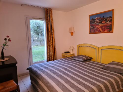 une chambre avec un lit et une grande fenêtre dans l'établissement Joli Mazet Provençal de Camargue, à Arles
