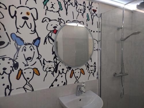 uma casa de banho com um espelho com cães na parede em Dunseverick Ramblers Rest em Bushmills