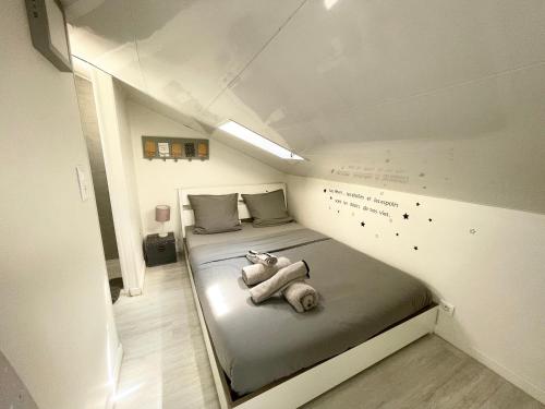a small room with a bed with a teddy bear on it at Homelivia, ATTIC ROOM -Mansardé sous les toits de Nice in Nice
