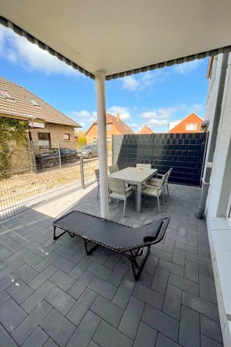 a patio with a table and a bench at Apartment Backbord by Interhome in Norddeich