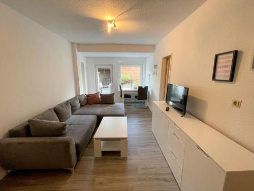 ein Wohnzimmer mit einem Sofa und einem TV in der Unterkunft Apartment Riff by Interhome in Norddeich