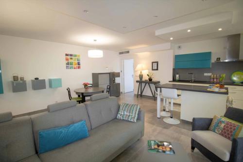 un salon avec un canapé et une cuisine dans l'établissement Beau 78m avec TERRASSE- résidence avec PISCINE, à Saint-Raphaël