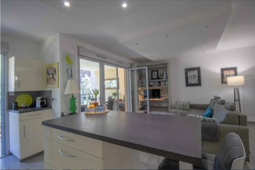 - une cuisine et un salon avec un grand comptoir dans l'établissement Beau 78m avec TERRASSE- résidence avec PISCINE, à Saint-Raphaël