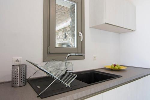 a kitchen sink with a dish drying rack next to it at Dreamy Cycladic Luxury Summer Villa 1 in Serifos Chora