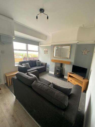 a living room with a couch and a tv at Ifan cottage - two bedroom cottage in Meliden