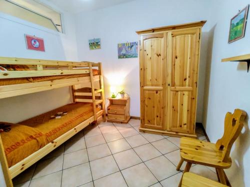 a bedroom with two bunk beds and a chair at Apartment Relax by Interhome in Gravedona