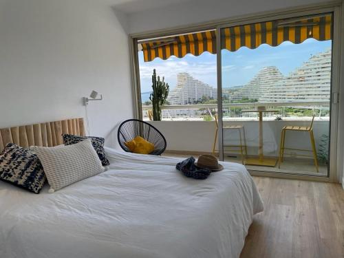 - une chambre avec un lit et un balcon dans l'établissement Grand 4 pièces 6 personnes fabuleuse vue mer clim garage, à Villeneuve-Loubet