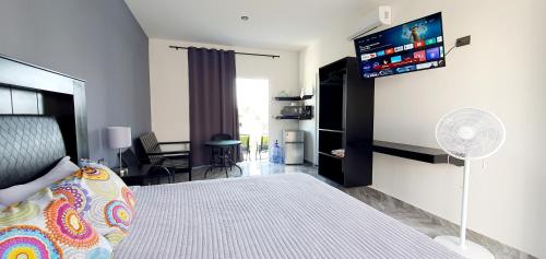a bedroom with a bed and a tv on the wall at Cozumel 568 - Vacation Rental in Cozumel