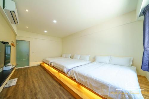 two beds in a room with white walls at 台南民宿 拾光旅宿-世平二館-預訂後聯繫才會保留 in Tainan
