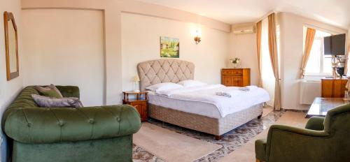 a bedroom with a bed and two chairs at Family Hotel Victoria Gold in Mineralni Bani