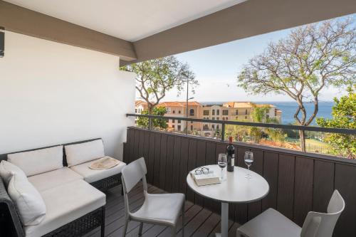 a balcony with a table and chairs and a view of the ocean at Florasol Residence Hotel - Dorisol hotels in Funchal