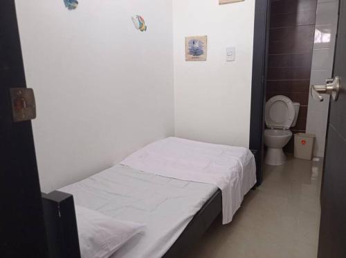 um pequeno quarto com uma cama e um WC em Acogedor apartamento con excelente vista al mar. em Santa Marta