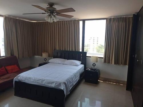 Un dormitorio con una cama y un ventilador de techo. en Acogedor apartamento con excelente vista al mar., en Santa Marta
