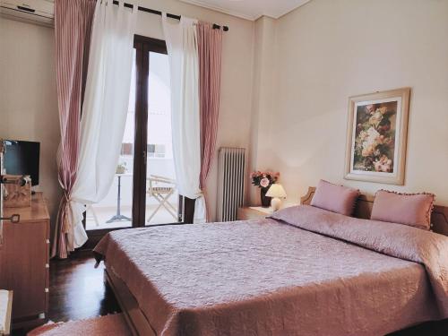 a bedroom with a large bed and a window at Christie's Boutique by Corfuescapes in Alepou