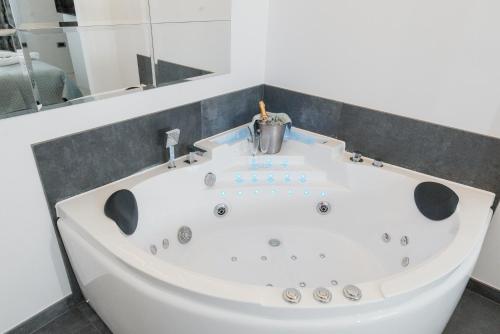 a white bath tub in a bathroom with a mirror at Vinceia in Smederevo
