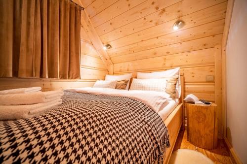 a bedroom with a bed in a wooden cabin at Przedsionek Tatr in Zakopane