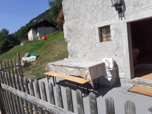 einem Tisch und einer Bank vor einem Gebäude in der Unterkunft Baita Martin da Fist in Caderzone