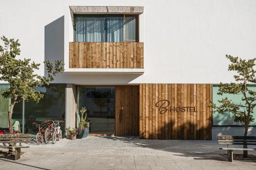 a building with a wooden door with a sign on it at B.Hostel in Comporta