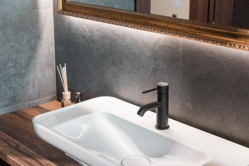 a bathroom sink with a faucet and a mirror at Vinceia in Smederevo