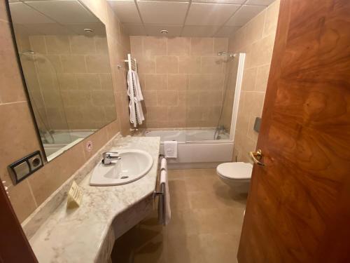 La salle de bains est pourvue d'un lavabo, d'une baignoire et de toilettes. dans l'établissement Hotel Cristina, à Noreña