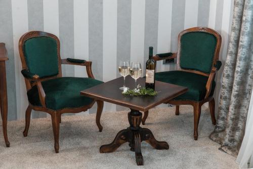 two chairs and a table with wine glasses and wine bottles at Vinceia in Smederevo