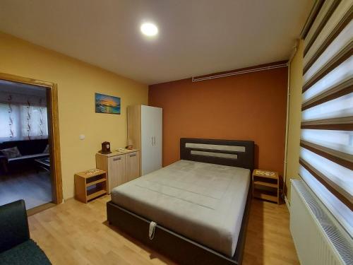 a small bedroom with a bed and a window at Apartman Jovičić in Višegrad