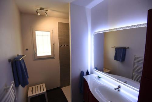 La salle de bains est pourvue d'une baignoire et d'un grand miroir. dans l'établissement villa des coteaux, à Ners