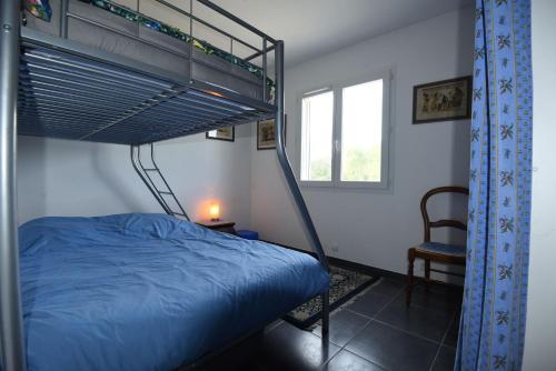 - une chambre avec des lits superposés et une chaise dans l'établissement villa des coteaux, à Ners