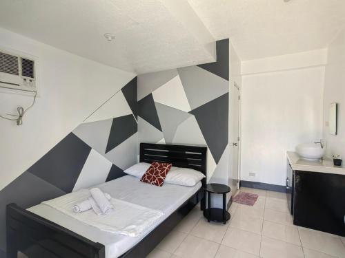 a bedroom with a black and white accent wall at AA TRAVELLERS PAD in Laoag