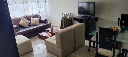 a living room with a couch and a tv at Apto Duplex Familias Numerosas Centro Pasto in Pasto