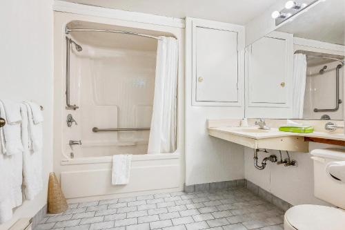 baño blanco con ducha y lavamanos en First Canada Hotel Cornwall Hwy 401 ON en Cornwall