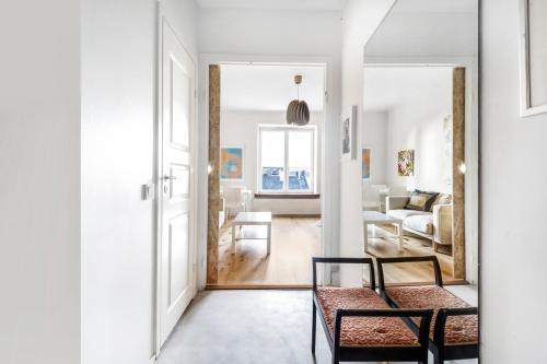 un soggiorno bianco con sedia e divano di WeHost 1BR Scandinavian Style Top Floor Apartment a Helsinki