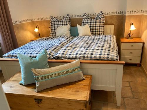 um quarto com uma cama com um banco e almofadas em Ferienwohnung Fröhlich em Alken