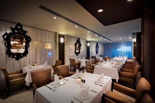 a dining room with white tables and chairs at Hard Rock Hotel Cancun - All Inclusive in Cancún