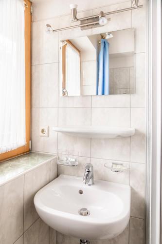 a white bathroom with a sink and a mirror at Pürstinghof in Flachau