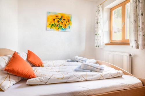 フラッハウにあるPürstinghofのベッド(オレンジ色の枕付)