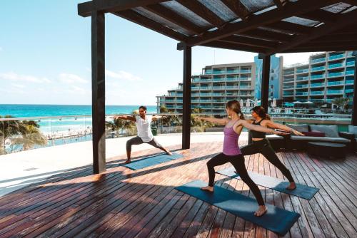 a group of people doing yoga at the beach at Hard Rock Hotel Cancun - All Inclusive in Cancún