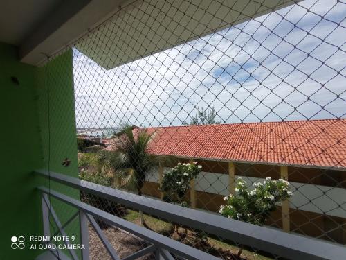 a view from a fence of a building with a red roof at Village Hospedagens in Natal
