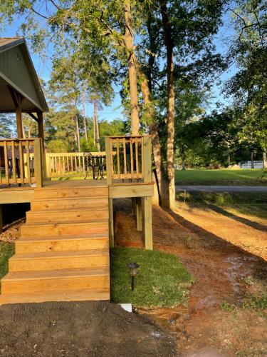 a wooden deck with a bench in a park at Cozy Cabin in Crestwood Subdivision in Avinger