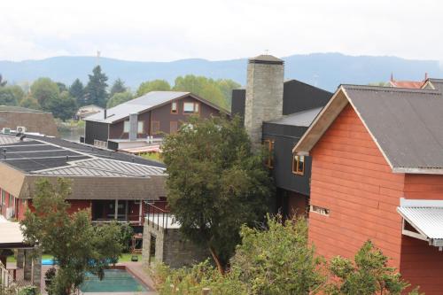 eine Gruppe von Häusern in einer Stadt mit Bäumen in der Unterkunft Hostal Capricho de Carlitos in Valdivia