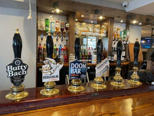 a bar with bottles of beer and signs on the counter at Punch House Monmouth in Monmouth