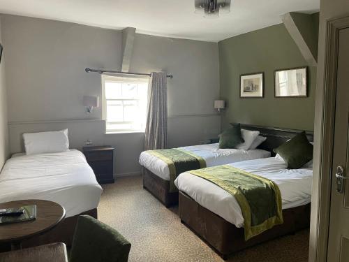 Habitación de hotel con 2 camas y ventana en Punch House Monmouth en Monmouth