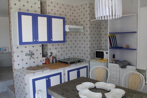 a small kitchen with blue cabinets and a table at La Rotonda in Anacapri