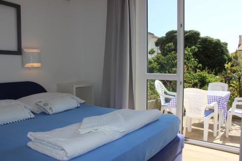 a bedroom with a bed and a view of a patio at Apartments Blue Sea in Mali Lošinj