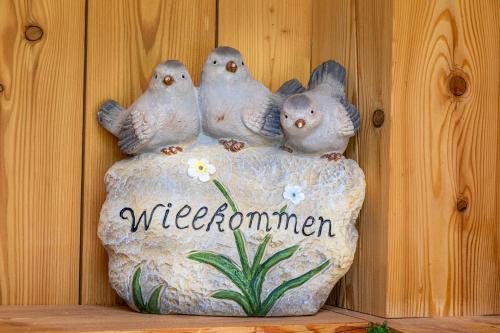 four birds sitting on a rock with a welcome sign at Ferienhaus Weitblick in Flachau