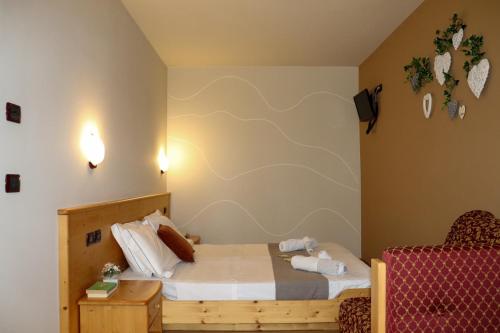 a small bedroom with a bed and a chair at hotel Parco Pineta in Cavareno
