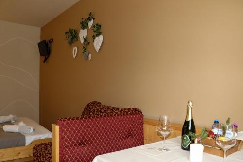 a room with a table with a bottle of champagne and a chair at hotel Parco Pineta in Cavareno