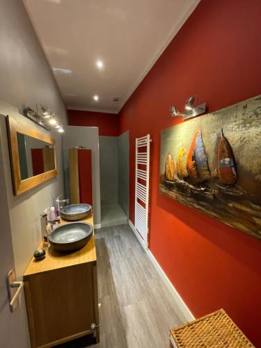 a bathroom with two sinks and a red wall at Magnifique grand appartement in Orange