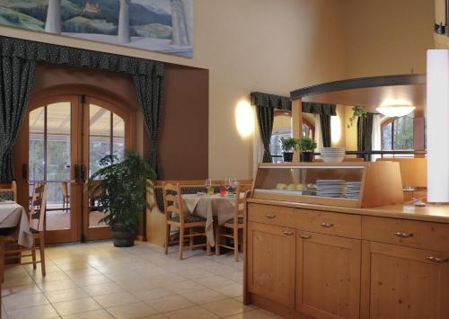 a kitchen with a table and a dining room at hotel Parco Pineta in Cavareno