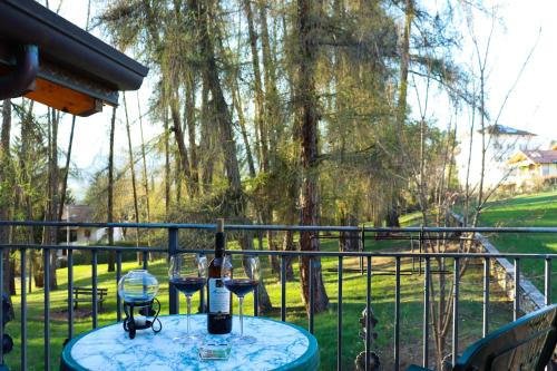 a table with a bottle of wine on a balcony at hotel Parco Pineta in Cavareno